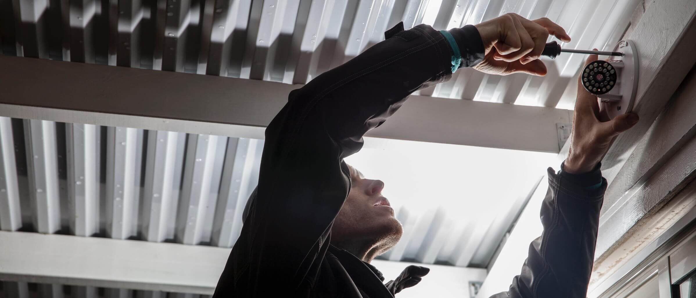 Man installing a SmartOffice dome camera.